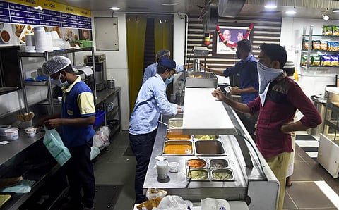 With the new restrictions coming into force, employees give away parcels to customers at a popular hotel chain in Triplicane on Monday. (Photo | Martin Louis, EPS)
