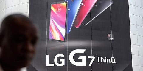 A visitor walks by an advertisement of LG Electronics' product at an electronic shop area in Seoul, South Korea. (Photo | AP)