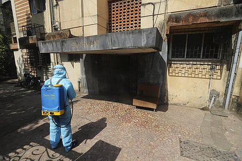 A civic worker sanitizes a building in Mumbai, India, Tuesday, April 6, 2021. (Photo | AP)