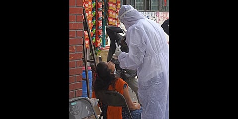 A health worker takes a swab sample of a woman for an RT-PCR test, in Bengaluru on Thursday. (Photo | Vinod Kumar T, EPS)