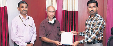 VIT registrar Dr K Sathiyanarayanan handing over the online transfer receipt for ` 1.25 crore as donation to DRO J Partheeban in Vellore | Express
