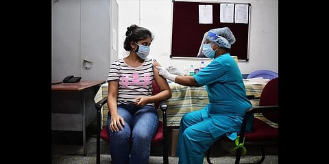 A health worker vaccinates a young woman at KC General Hospital in Bengaluru on Wednesday. (Photo | Shriram BN, EPS)