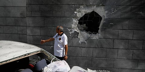 A man inspects the damaged wall of a residential building that was hit by a rocket fired from the Gaza Strip in Ashkelon, Israel. (Photo| AP)