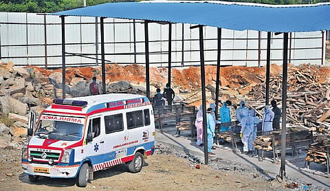 Family members perform the last rites of a person who succumbed to COVID-19, at an open-air crematorium on the outskirts of Bengaluru. (Photo| Ashishkrishna HP, EPS)