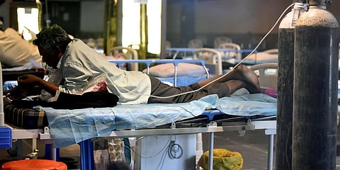 A COVID-19 patient takes rest inside a temporarily converted isolation ward in a banquet hall in New Delhi. (Photo| ANI)