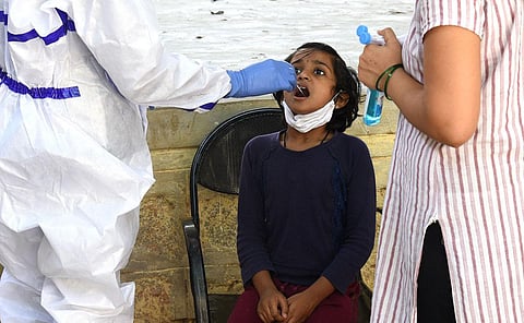 A young girl gives her swab samples for a Covid test at a Primary Health Centre in Bengaluru. (Photo | Vinod Kumar T, EPS)