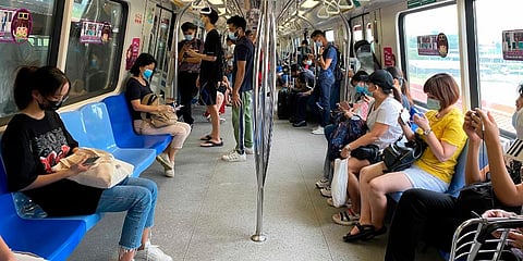Commuters wear face masks and practice social distancing while onboard a subway in Singapore. (Photo | AP)