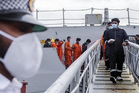 People rescued by the Indian navy from a barge that sank in the Arabian sea walk out from Indian naval ship INS Kochi in Mumbai. (Photo | AP)