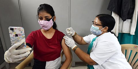 A medic administers the dose of vaccine to a beneficiary, at Moti Lal Nehru Medical College vaccination in Prayagraj. (Photo | ANI)