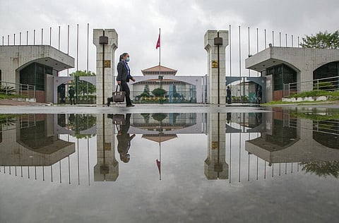 A Nepalese woman walks in front of parliament building in Kathmandu. (Photo | AP)
