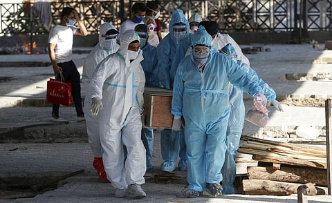 Health workers and relatives carry the body of a COVID-19 victim for cremation in Jammu. (File Photo | AP)