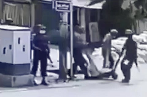 In this March 13, 2021 image from video obtained by The Associated Press, security forces carry the body of an unidentified individual in the Sein Pann ward of Mandalay, Myanmar. (Photo | AP)