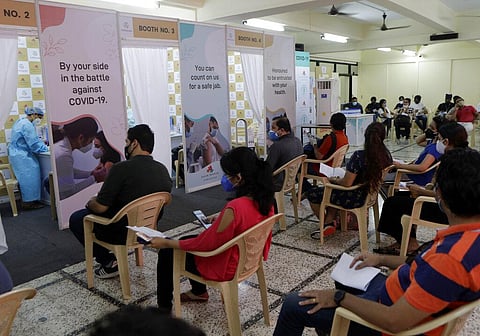 People wait to receive vaccine for COVID-19 at a vaccination centre in Mumbai. (Photo | AP)