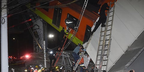 Fire fighters and rescue personnel work to recover victims from a subway car that fell after a section of Line 12 of the subway collapsed in Mexico City. (Photo| AP)