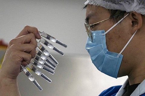 In this Sept. 24, 2020, file photo, a worker inspects syringes of a vaccine for COVID-19 produced by Sinovac at its factory in Beijing. (Photo | AP)