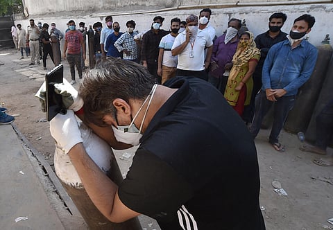 Relatives of a COVID-19 patients along with others waits to refill cylinders with medical oxygen during the second wave of coronavirus pandemic in India, in New Delhi. (Photo | PTI)