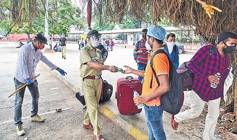 Volunteers from an NGO distribute food and water to passengers waiting for trains at the City Railway Station in Bengaluru on Tuesday | Shriram BN