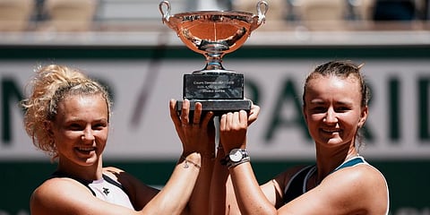 Barbora Krejcikova (R)Â and compatriot Katerina Siniakova hold the cup after defeating Bethanie Mattek-Sands and Iga Swiatek in their women's doubles final match of the French Open. (Photo | AP)