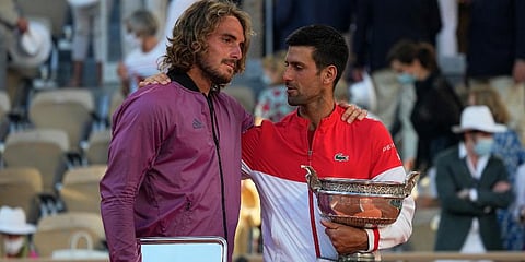 Novak Djokovic (R) and Stefanos Tsitsipas hug while holding their trophies after their final match of the French Open tennis tournament at the Roland Garros stadium. (Photo | AP)