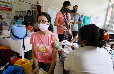 A health worker administers a dose of a COVID-19 vaccine to a woman at a Railway hospital in Prayagraj. (File photo| PTI)