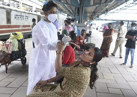 A BMC health worker collects swab sample of a passenger for COVID-19 testing, at Dadar railway station in Mumbai, Tuesday, June 22, 2021. (Photo | PTI)