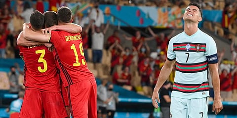 Cristiano Ronaldo (R) reacts as Belgium players celebrate following the Euro 2020 round of 16 match between Belgium and Portugal at La Cartuja stadium, Seville. (Photo | AP)