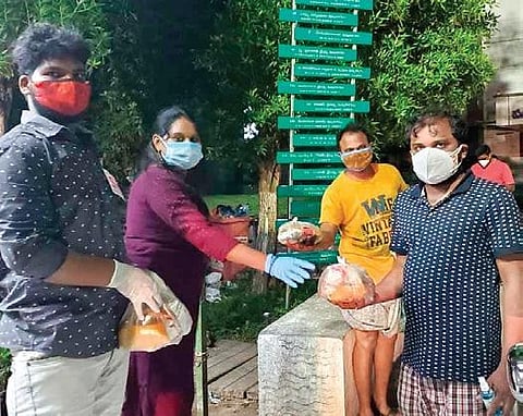 Varanasi Santoshi Raj distributes food packets to Covid-19 patients in home isolation in Vizianagaram. (Photo | Express)