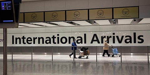 Arriving passengers walk past a sign in the arrivals area at Heathrow Airport in London. (File photo| AP)