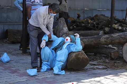 In this April 25, 2021, file photo, a relative of a person who died of COVID-19 breaks down during cremation in Jammu, India. (Photo | AP)