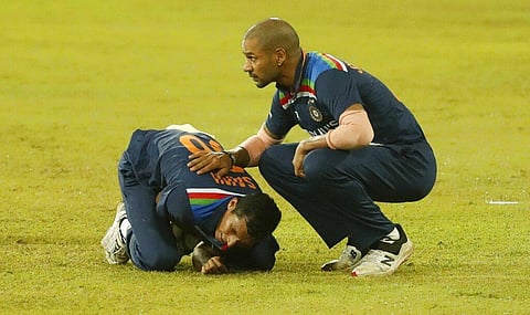 India's Navdeep Saini holds his arm in pain as Shikhar Dhawan attends during their second Twenty20 cricket match with Sri Lanka in Colombo. (Photo | AP)