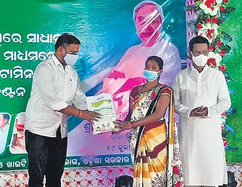 IT and Sports Minister Tusharkanti Behera distributing fortified rice to a woman in Malkangiri on Thursday | Express