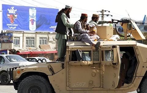 Taliban fighters stand guard in front of the Hamid Karzai International Airport, in Kabul, Afghanistan. (Photo | AP)