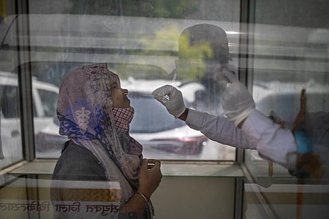 A health worker takes a swab sample to test for COVID-19 at a government hospital. (File Photo | AP)