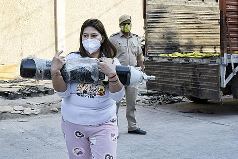 A family member of a COVID-19 patient seen carrying an oxygen cylinder for refilling, during the height of the second wave. (Photo | PTI)