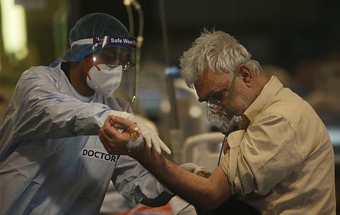 A Covid-19 patient on an oxygen support inside a Covid-19 care center set up at Shehnai Banquet in New Delhi. (Photo | Shekhar Yadav, EPS)