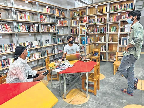 A student leader turned librarian, a student leader and an intern engaged in a discussion at the Khirki library. (Photo | Express)