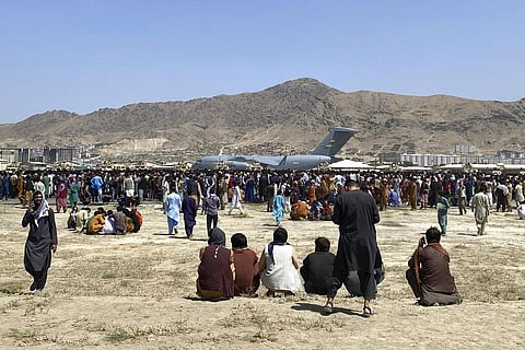 Hundreds of people gather near a U.S. Air Force C-17 transport plane at the perimeter of the international airport in Kabul. (File Photo | AP)