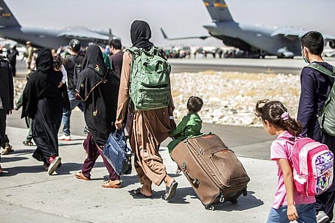 Families walk towards their flight during ongoing evacuations at Hamid Karzai International Airport, in Kabul. (Photo | AP)