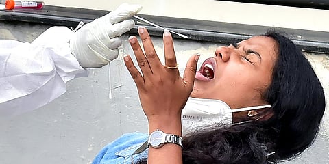 A healthcare worker takes a swab sample of a woman for the COVID-19 testing. (File Photo| ANI)
