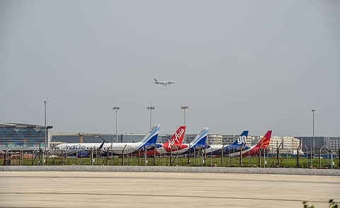 A plane lands at IGI Airport as others stand parked in New Delhi. (Photo | PTI)