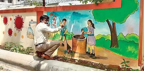 Outsourced drawing teacher Y.Satyanarayana paints a wall of AVNM High School under Nadu-Nedu programme | Express