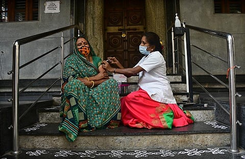 A health worker administers vaccine at camp in a temple in Bengaluru. (Photo | Ashishkrishna HP, EPS)
