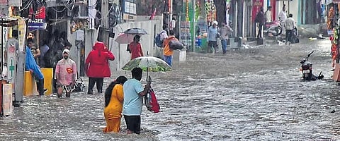 People wade through rainwater in Krishnanagar in Hyderabad on Monday. (Photo | R V K Rao)