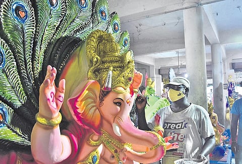 An artist giving final touches to Lord Ganesh idols ahead of Ganesh Chaturthi at Nunna in Vijayawada on Sunday | P Ravindra Babu