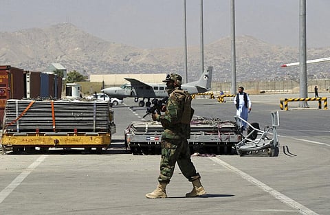 A Taliban soldier walks on the tarmac at Hamid Karzai International Airport in Kabul, Afghanistan, Sunday, Sept. 5, 2021. (Photo | AP)