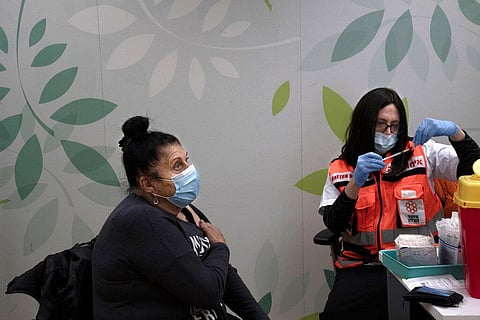 Esther Pamensky, a volunteer with the women's unit of United Hatzalah emergency service, prepares a fourth dose of the COVID-19 vaccine. (Photo | AP)