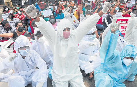 Wearing PPE kits, members of All Kerala Covid Brigade Association protest in front of the secretariat on Thursday urging the government to disburse their risk allowance that has been pending over the