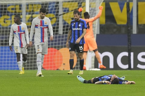 Inter Milan's Lautaro Martinez lies on the ground celebrating at the end of the Champions League match between Inter Milan and Barcelona (Photo | AP)