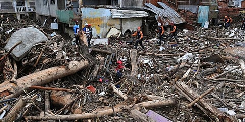Rescue teams and family members search through the rubble of houses swept away by the flooding of a creek, in Las TejerĂas, Aragua state, Venezuela, on October 9, 2022.(Photo | AFP)