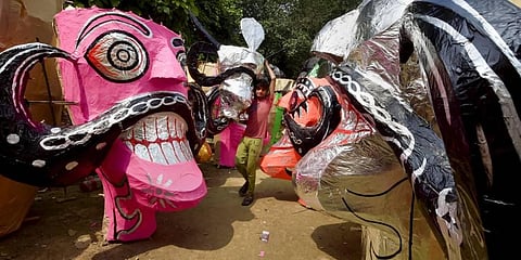 An artisan carries an effigy of demon King Ravana ahead of the Dussehra festival, in New Delhi. (Photo | PTI)